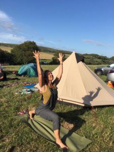 woman doing yoga in a campsite