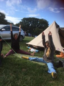 Sharon doing sitting yoga pose in a campsite