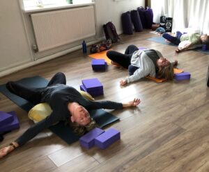 people doing restorative yoga pose